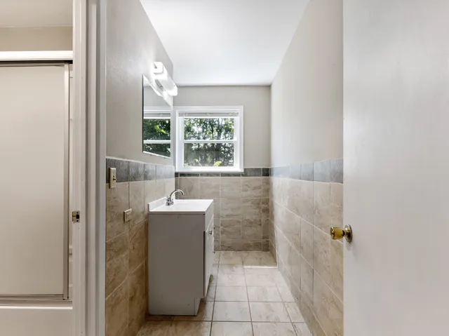 a bathroom with a sink and mirror with bathtub