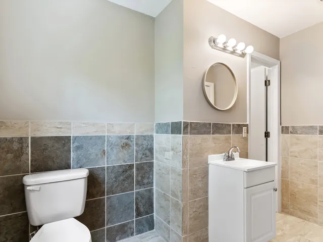 a bathroom with a toilet sink and mirror