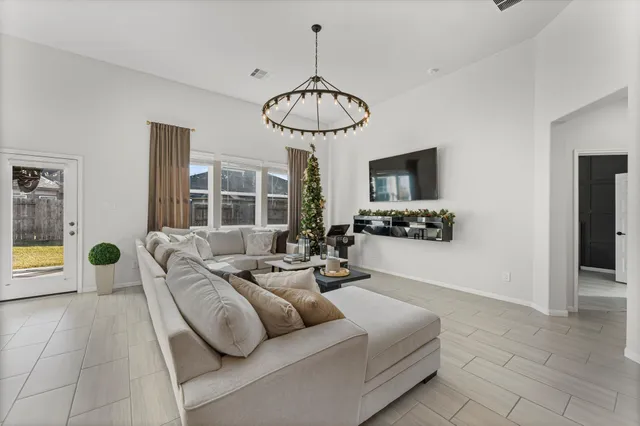 a living room with patio furniture and a chandelier