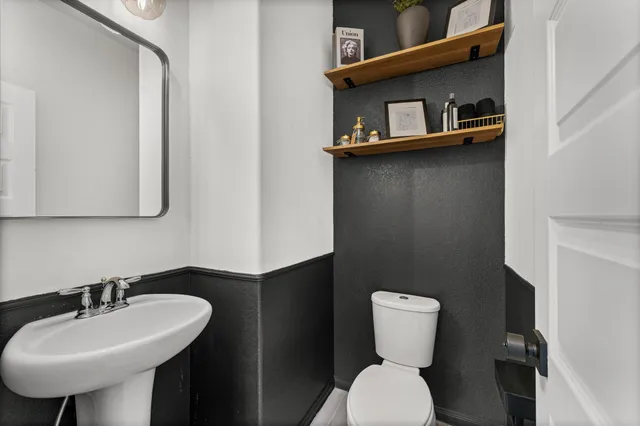 a bathroom with a toilet sink and mirror