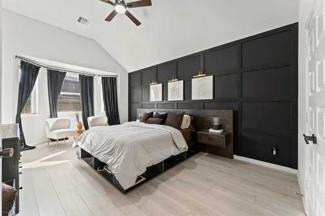 a bedroom with a large bed and a large window