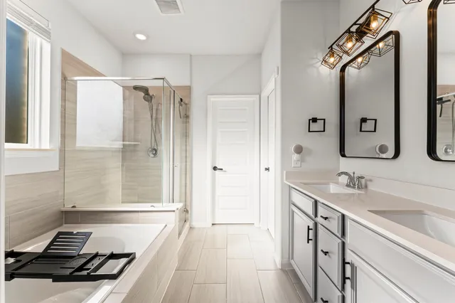 a bathroom with a double vanity sink a mirror and a shower