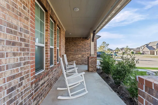 a balcony with chairs and potted plants