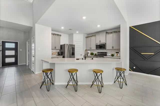 a kitchen with refrigerator and chairs