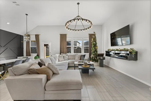 a living room with furniture a window and a flat screen tv