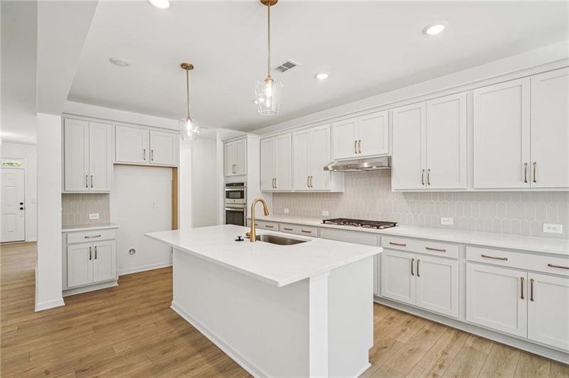 240 Silverleaf Trail Bethlehem, GA 30620 - Photo 7 of 35 a kitchen with stainless steel appliances granite countertop a white stove top oven and white cabinets