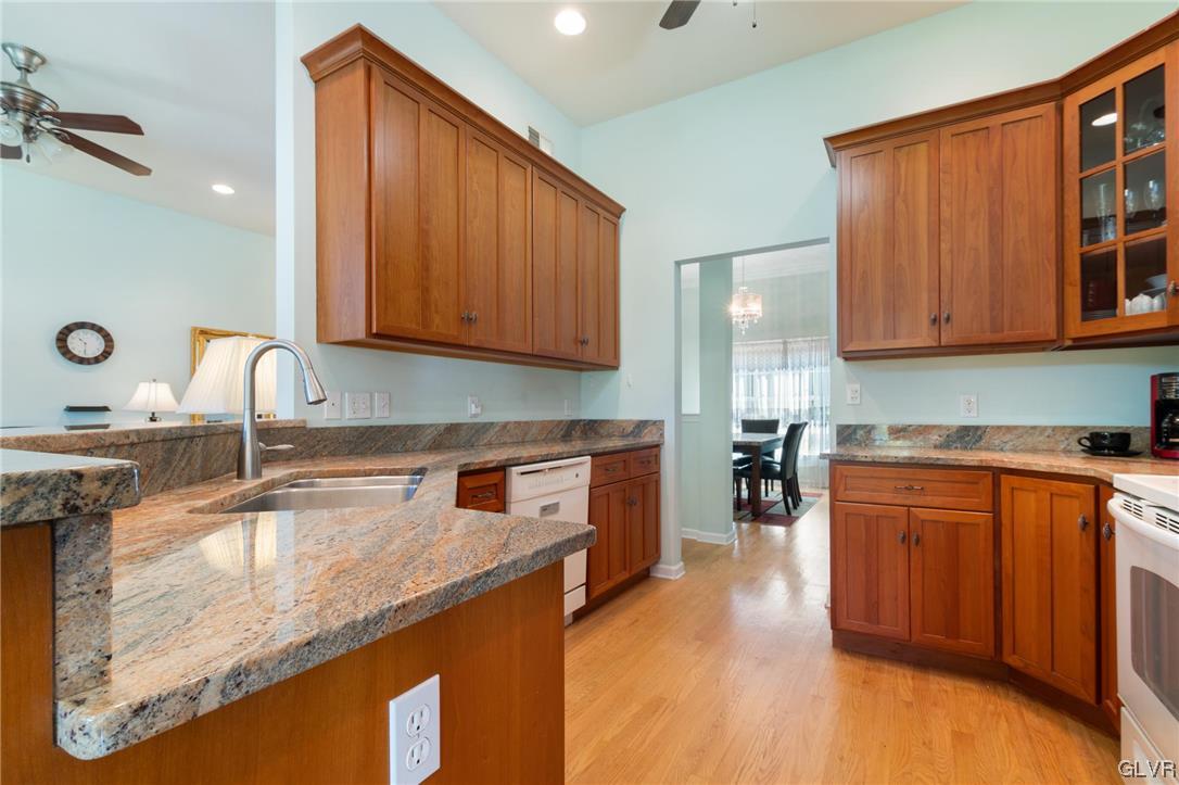 1206 Shiloh Road Allentown, PA 18106 - Photo 16 of 28 a kitchen with granite countertop wooden cabinets a sink and dishwasher a stove with wooden floor