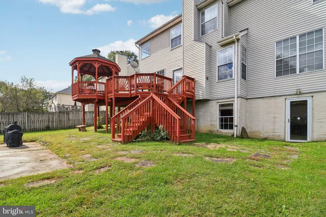a view of a backyard with a large tree and wooden fence