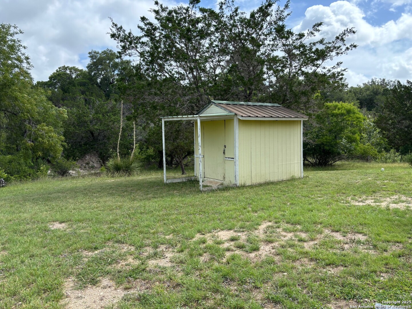 952 Madrona Road Pipe Creek, TX 78063 - Photo 19 of 33 a backyard of a house with plants and large trees