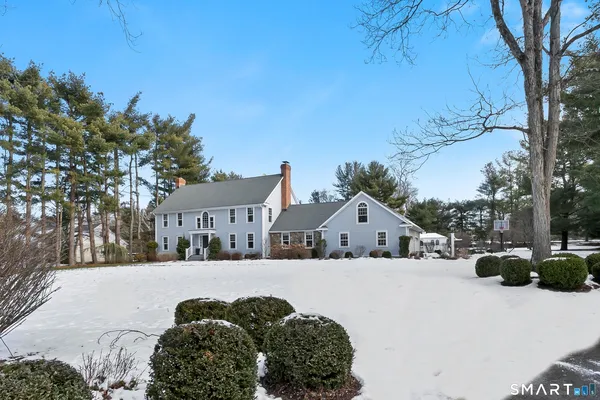 a front view of a house with a yard covered in snow