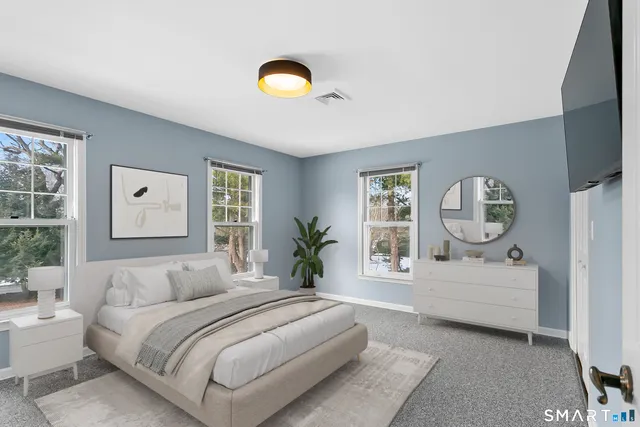 a spacious bedroom with a bed window and couch