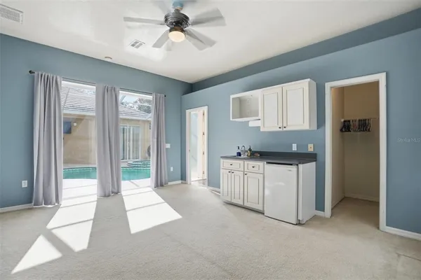 a open kitchen with white cabinets and refrigerator