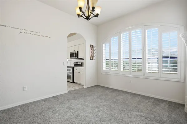a view of a big room with windows and chandelier fan