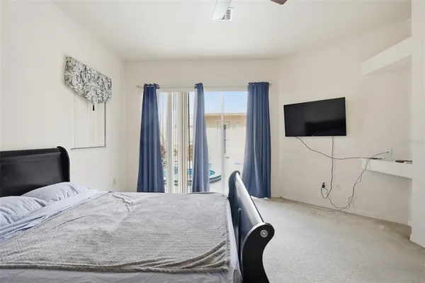 a bedroom with a bed tv and chair