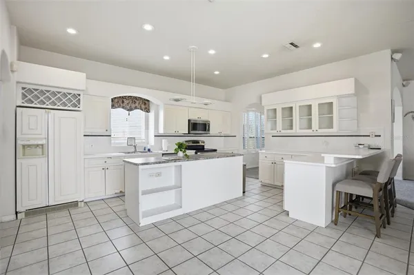 a kitchen with a sink and chairs