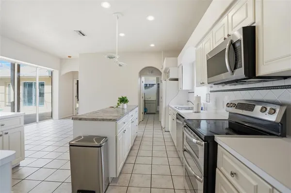 a kitchen with stainless steel appliances a stove a sink and a refrigerator