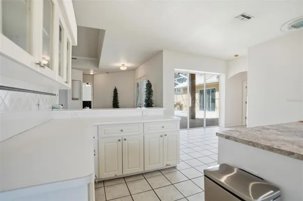 a large white kitchen with granite countertop a sink white cabinets and a granite counter tops