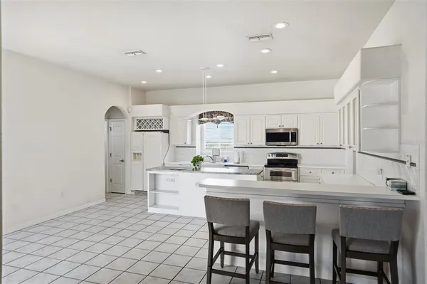 a kitchen with stainless steel appliances kitchen island granite countertop a sink and cabinets