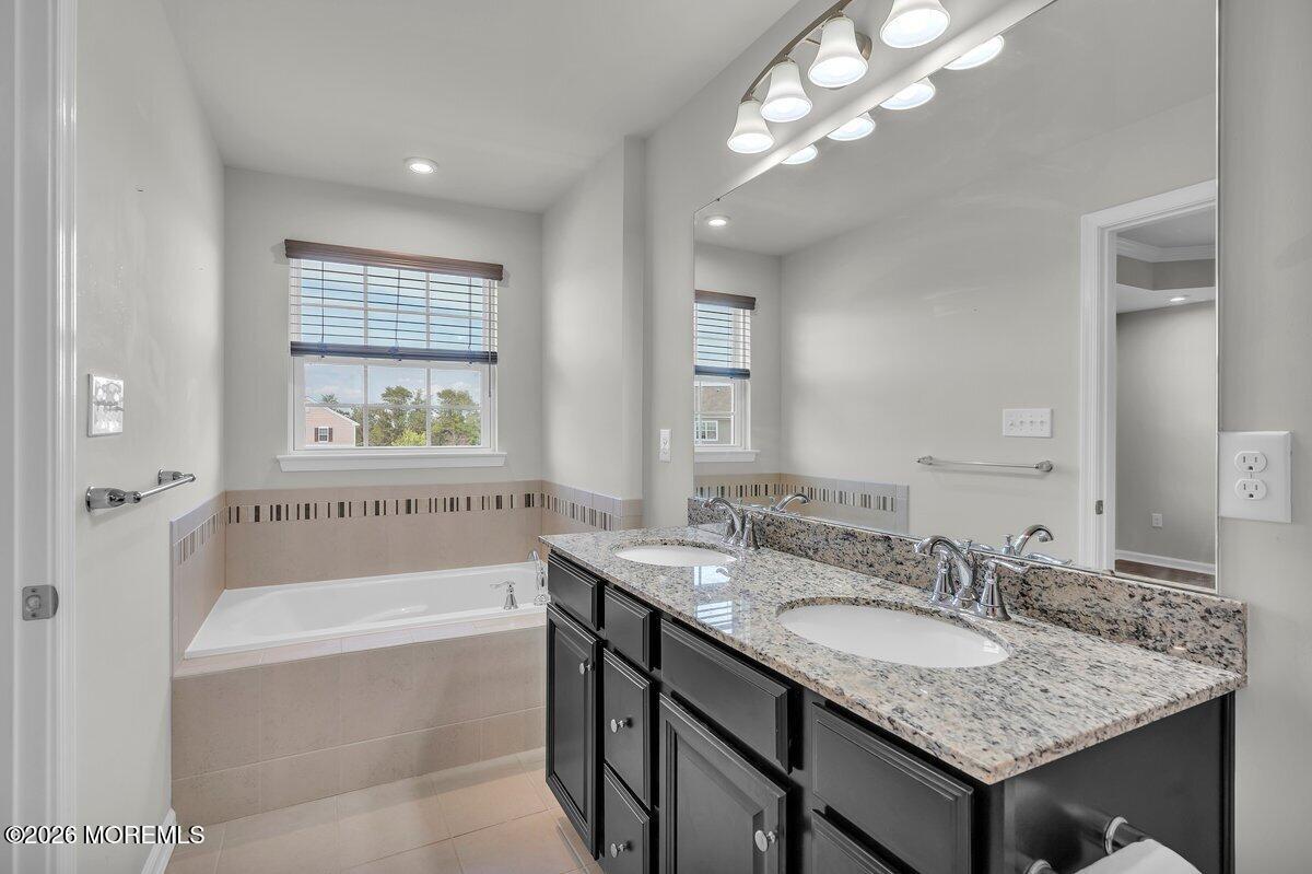 411 Sammy Street Swedesboro, NJ 08085 - Photo 16 of 24 a bathroom with a granite countertop bathtub a sink and a mirror