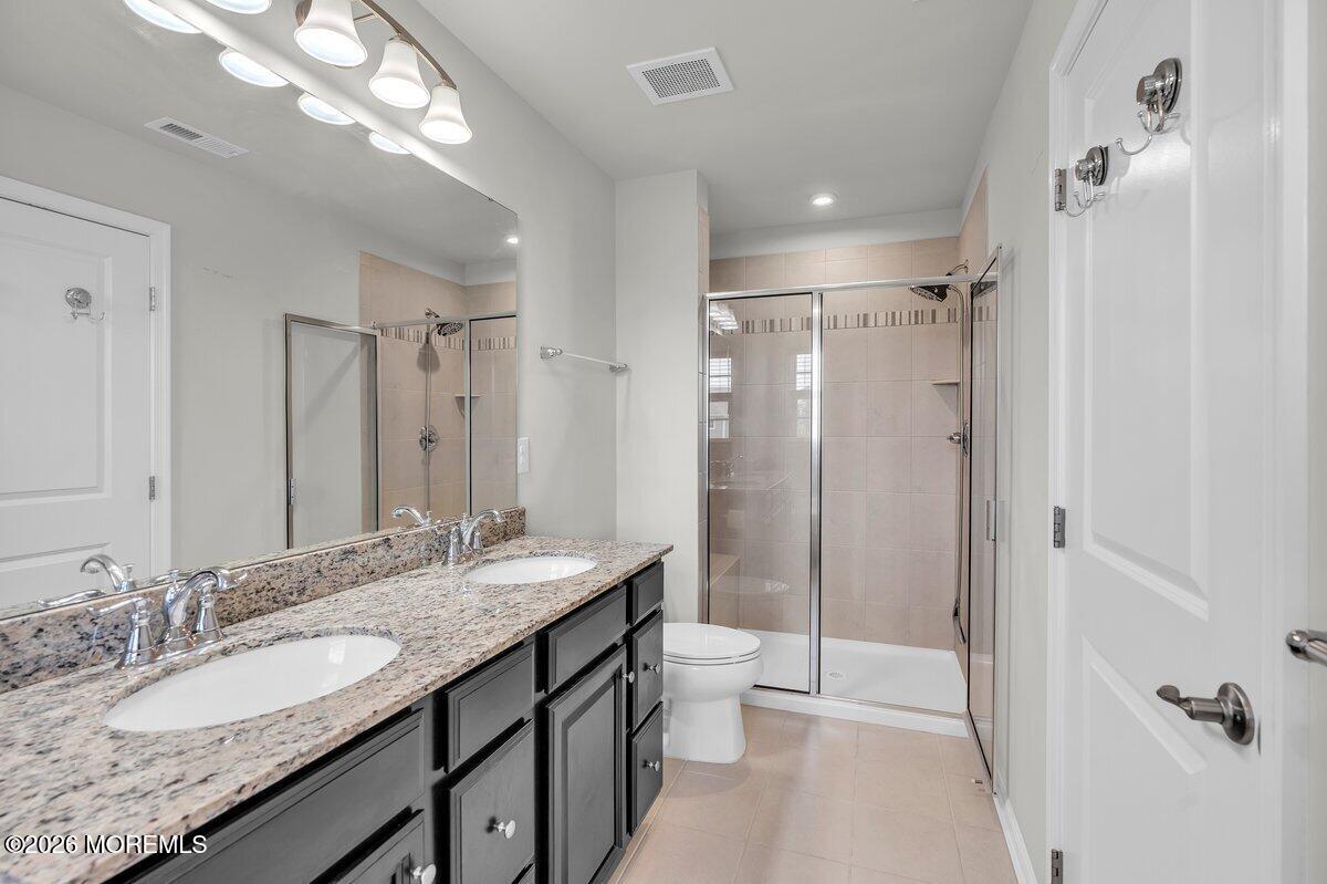 411 Sammy Street Swedesboro, NJ 08085 - Photo 17 of 24 a bathroom with a granite countertop sink a toilet a mirror and shower