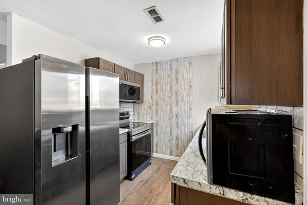 a kitchen with stainless steel appliances granite countertop a refrigerator and a stove