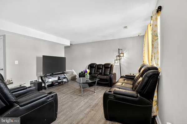 a living room with furniture a flat screen tv and a window