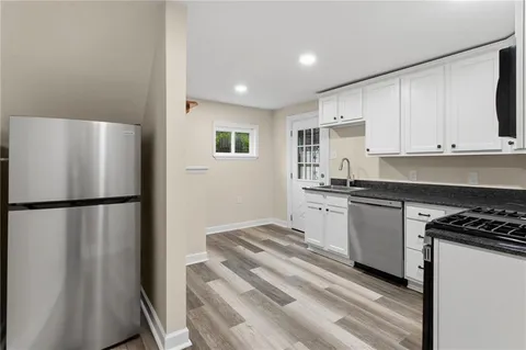 a kitchen with a refrigerator and a stove top oven