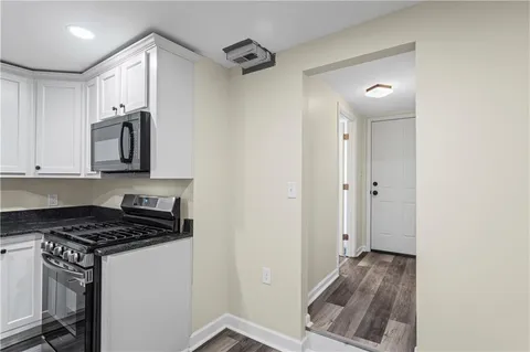 a kitchen with a refrigerator and a stove top oven