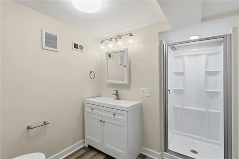 a bathroom with a sink a toilet and shower