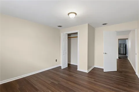 an empty room with wooden floor and closet