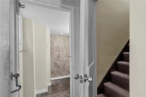 a view of a hallway with wooden floor and staircase