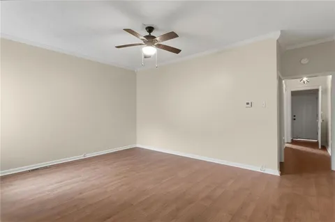 a view of an empty room with chandelier fan