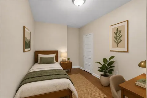 a bedroom with a large bed and a potted plant