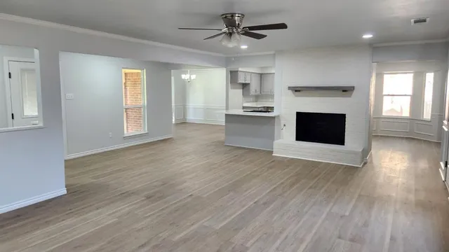 an open kitchen with wooden floor and a fireplace