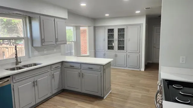 a kitchen with a sink cabinets appliances and a window