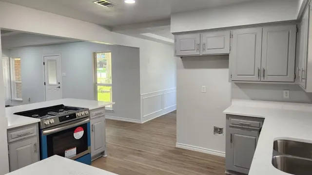 a kitchen with stainless steel appliances a stove a sink and a refrigerator