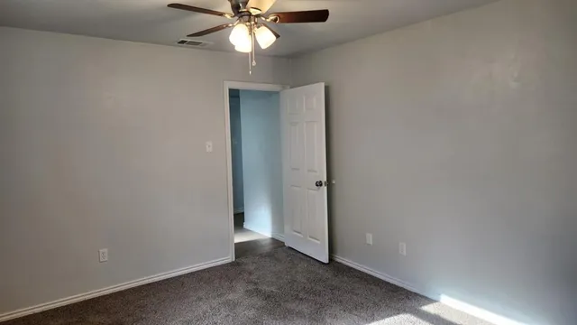an empty room with a fan and a fan