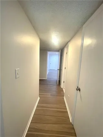 a view of a hallway with wooden floor and staircase