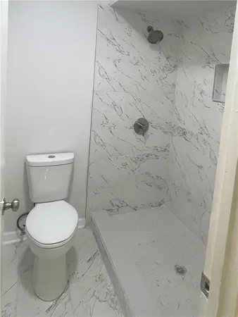 a white toilet sitting next to a shower
