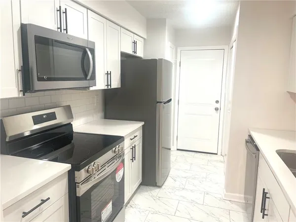 a kitchen with stainless steel appliances granite countertop a refrigerator stove and microwave