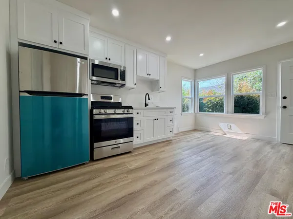 a kitchen with granite countertop a refrigerator and a sink