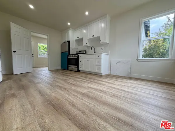 a view of a kitchen with wooden floor and windows