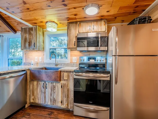 a kitchen with stainless steel appliances granite countertop a sink a stove and cabinets