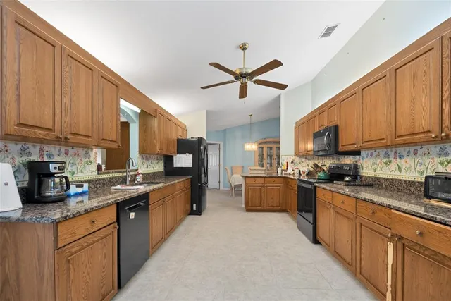 a kitchen with stainless steel appliances granite countertop a sink stove cabinets granite counter tops and a window