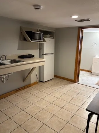 a kitchen with a sink a refrigerator and wooden cabinets