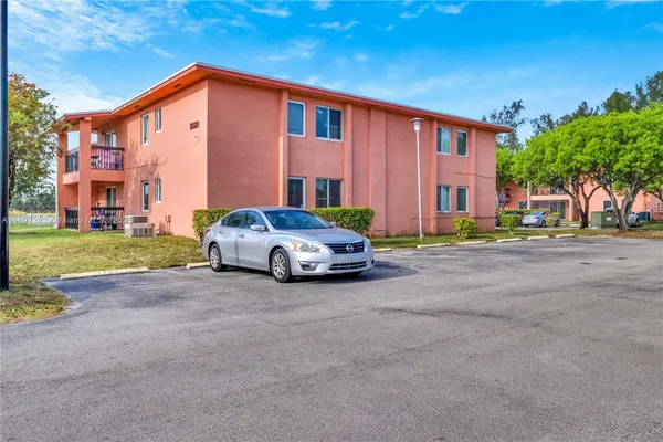 a car parked in front of a house next to a yard