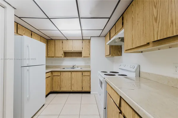 a kitchen with stainless steel appliances granite countertop a sink a stove and refrigerator