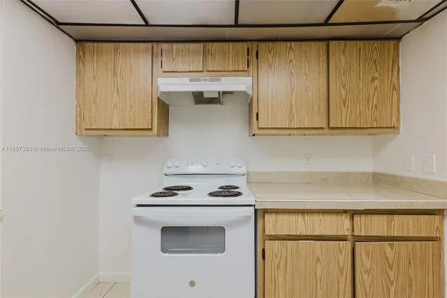 a kitchen with stainless steel appliances a stove a microwave and white cabinets