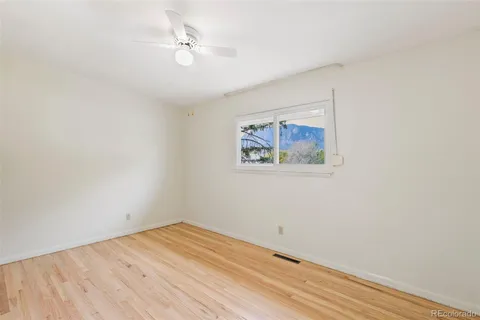 an empty room with a window and a ceiling fan