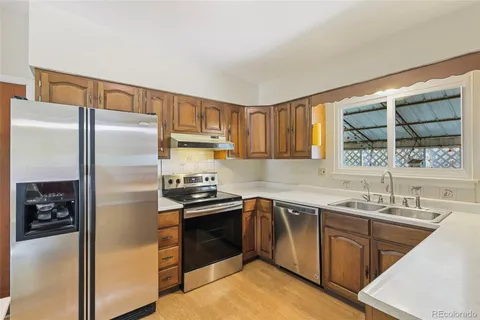 a kitchen with stainless steel appliances granite countertop a refrigerator and a sink